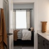 a bathroom with a sing and mirror with view of a bedroom